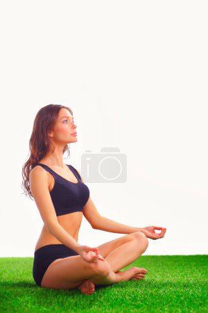 Téléchargez les photos : Femme assise avec les jambes croisées sur l'herbe verte - en image libre de droit