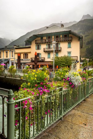 Foto de Chamonix Mont-Blanc, Francia - 4 de octubre de 2019: Flores y café callejero en el centro de la famosa estación de esquí en los Alpes franceses - Imagen libre de derechos