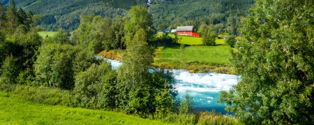 Foto de Paisaje noruego con río, montañas de verano y pueblo en Olden, Noruega - Imagen libre de derechos