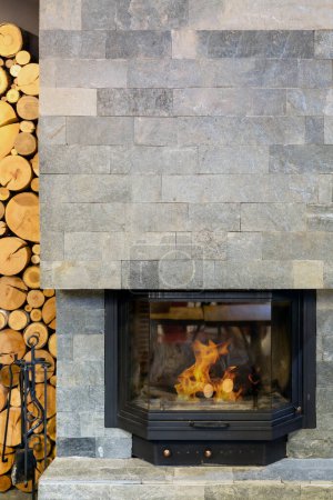 Photo for Stone Fireplace with Flames of burning fire, Rustic Style Cozy Home in Winter - Royalty Free Image