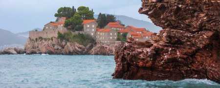 Foto de Hotel en la isla de Sveti Stefan al atardecer, cerca de Budva, Montenegro, bandera - Imagen libre de derechos