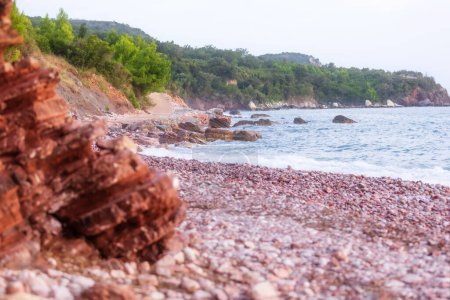 Playa salvaje Crvena Glavica en Montenegro. Rocas rojas costa y olas de agua