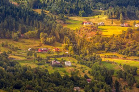 Sonnenuntergang norwegische Dorflandschaft, grüne Waldberge und bunte Häuser, Norwegen