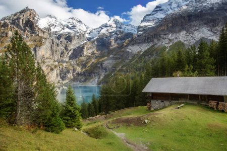 Amazing tourquise Oeschinnensee lake, wooden chalet and Swiss Alps, Berner Oberland, Switzerland.