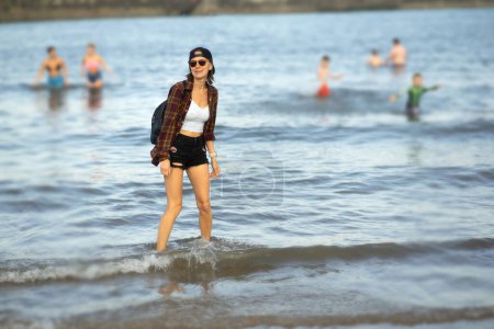 Photo for Discovering the North sea in the North of England, woman walking in the sea enjoying last summer days. Hot summer days in the North of England - Royalty Free Image
