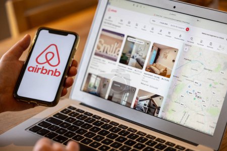 Foto de París, Francia - 30 de noviembre de 2023: Smartphone de mano femenina con aplicación Airbnb. Airbnb es un mercado en línea y un servicio de hospitalidad, que permite a las personas alquilar o alquilar alojamiento a corto plazo - Imagen libre de derechos