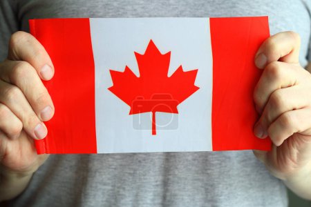 Téléchargez les photos : Gros plan, le drapeau du Canada entre les mains d'un homme. - en image libre de droit