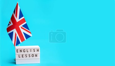 Téléchargez les photos : Drapeau de Grande-Bretagne et l'inscription sur l'assiette leçon d'anglais, bannière sur fond bleu. - en image libre de droit