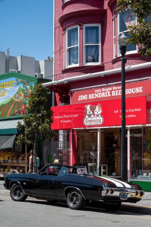 Foto de Haight Ashbury Street, San Francisco, California, Estados Unidos - 22 de abril de 2023: Exterior de la Casa Roja de Jimi Hendrix con un clásico automóvil estadounidense en la puerta contra un cielo azul sin nubes a la luz del día - Imagen libre de derechos