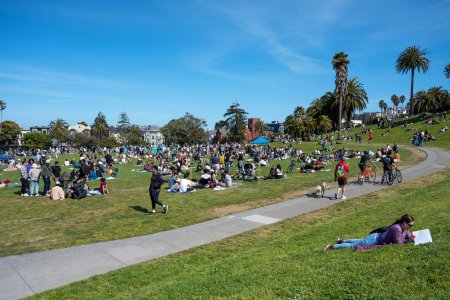 Foto de San Francisco, California - 25 de abril de 2023: Gente disfrutando del tiempo libre en el Parque Mission Dolores durante la primavera contra el cielo azul - Imagen libre de derechos