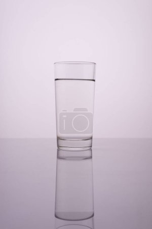 Téléchargez les photos : Verre d'eau propre sur fond blanc gris. - en image libre de droit