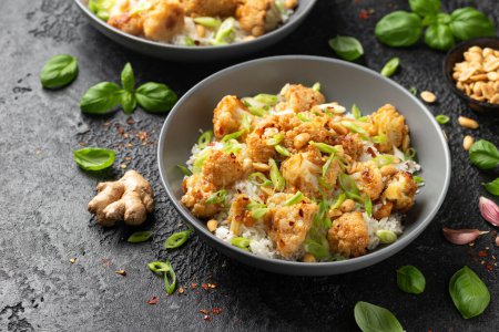Foto de Coliflor de Kung Pao con arroz, maní y especias. Comida vegana saludable - Imagen libre de derechos