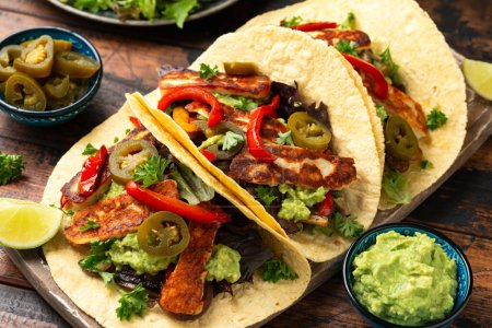 Photo for Fried halloumi fajitas with pan roasted onions and bell peppers, avocado guacamole and pickled jalapeno peppers. - Royalty Free Image