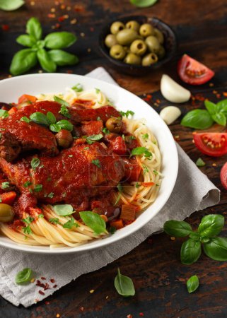 Photo for Cacciatore Chicken with spaghetti, vegetables, olives and tomatoes. - Royalty Free Image