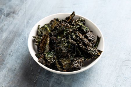 Kale chips, snack in white bowl. Healthy vegetable food