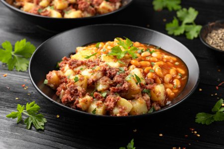 Corned beef hash with potatoes and beans in tomato sauce