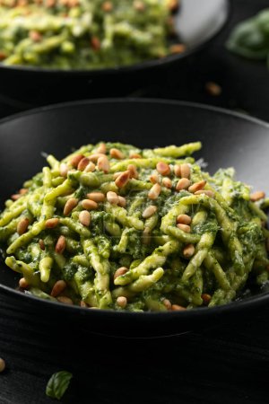 Trofie pasta with creamy spinach sauce and toasted pine nuts.