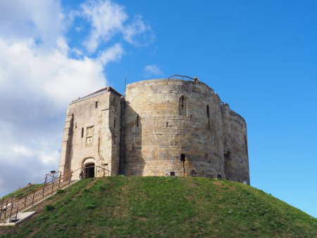 Téléchargez les photos : Le donjon du château de York connu sous le nom de Cliffords Tower vu sous un ciel bleu vif - en image libre de droit