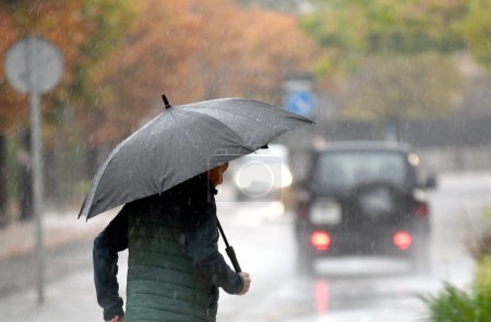 Foto de Personas con sombrillas y ropa de abrigo debido a un día lluvioso en Mallorca. 10 de noviembre de 2022. - Imagen libre de derechos