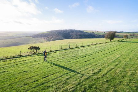 Photo for Beautiful countryside in Pewsey, Wiltshire. Backpacker walking in footpath outdoor, spring daytime - Royalty Free Image