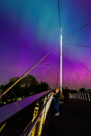 Téléchargez les photos : Les gens regardent dans le ciel à l'événement insolite d'astronomie, Aurora Northern Light dans le centre-ville de Reading, Berkshire, Angleterre, été 2024 - en image libre de droit