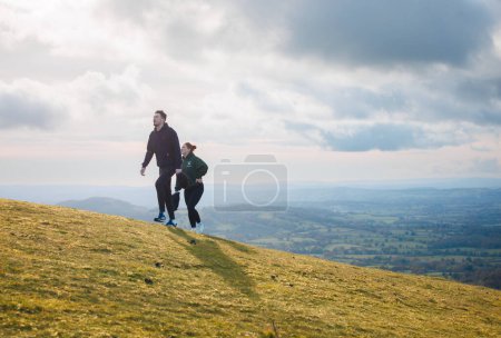 Hiker walking on uphill of Malvern Hills National Landscape, United Kingdom, Winter