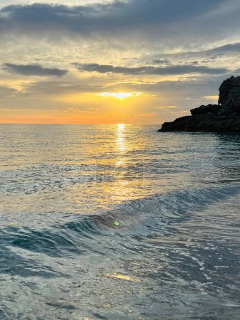 Landschaftlich reizvoller Sonnenuntergang über dem ionischen Meer in Vlore Albanien. Wunderschönes plätscherndes Wasser mit ruhigen Wellen. Vertikales Foto. Kopierraum.