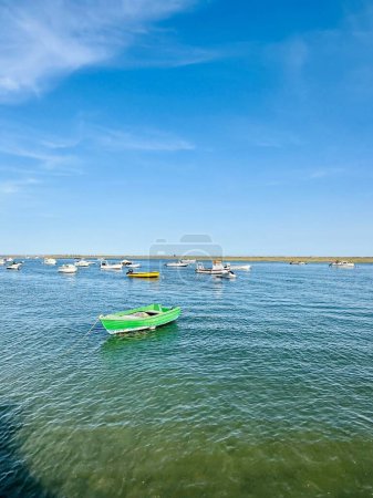 Photo for Canal de Tavira , Eastern Algarve.Portugal. Small boat cruising tranquil green river. - Royalty Free Image