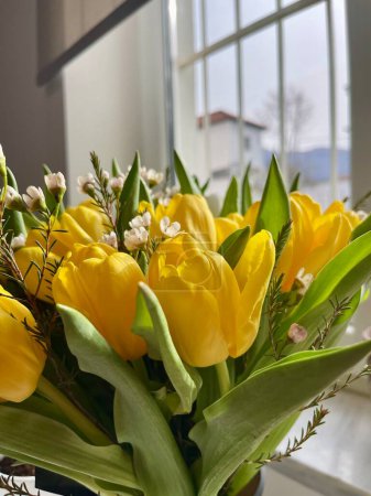 Photo for Close up Yellow tulips with green leaves. Copy space. Floral background. Vertical Photo. - Royalty Free Image