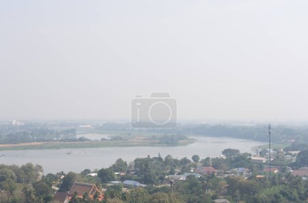 Téléchargez les photos : Vue du village et de la rivière dans la zone rurale de la Thaïlande le jour brumeux en raison de la pollution atmosphérique PM2.5 - en image libre de droit