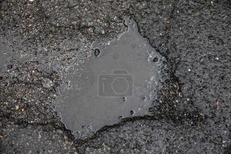 Road damage caused by potholes in the asphalt of the roadway