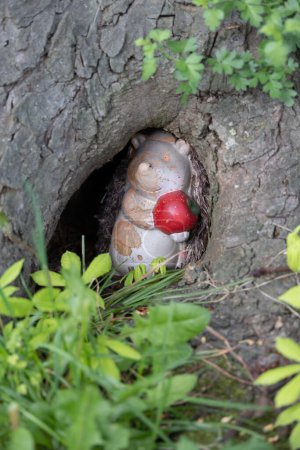 little hedgehog hiding in a tree hole