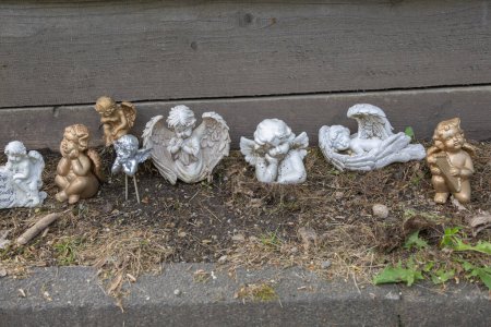 Small porcelain angels in a row as grave decorations