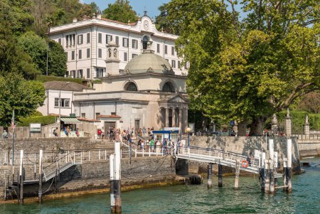Photo for Tremezzina, Lombardy, Italy - September 5, 2022: The pier of the villa Carlotta in Tremezzina village with tourists are waiting for the ferry boat for sightseeing on Lake Como. - Royalty Free Image