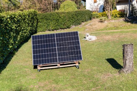 Foto de Paneles fotovoltaicos en la plataforma de madera en el jardín del hogar. Concepto de energía verde. - Imagen libre de derechos
