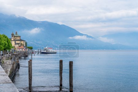 The pier with a ferry boat in Cannobio on the lake Maggiore, province of Verbano Cusio Ossola in Piedmont, Italy