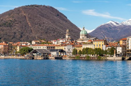 Panoramic view of the Intra town from Lake Maggiore with snow-capped mountains in the background, Verbania, Piedmont, Italy