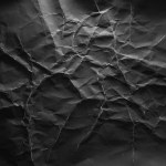 Black crumpled paper with lightning-like texture background