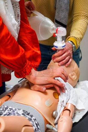 Téléchargez les photos : Les médecins généralistes sont formés aux procédures d'urgence pédiatriques. Un enfant souffre de graves difficultés respiratoires. Ventolin est administré à l'aide d'un espaceur. - en image libre de droit