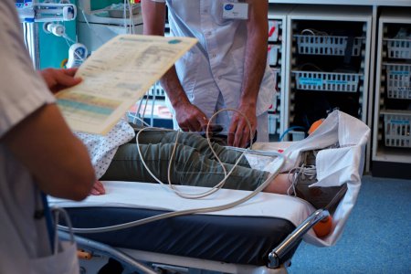 Foto de Paciente en la sala de shock de la unidad de cuidados intensivos de un hospital universitario. Preparación de una lectura de glucosa en sangre. - Imagen libre de derechos