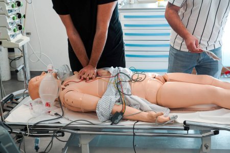Photo for For two days, nurses and emergency nurses undergo training at the Montpellier School of Medicine on emergency procedures and resuscitation. Simulation session on a SimMan dummy. Cardiac massage and installation of a defibrillator. - Royalty Free Image