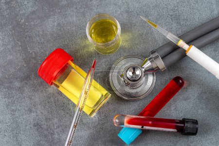 Téléchargez les photos : Stéthoscope entouré de tubes sanguins et de bouteilles d'urine. - en image libre de droit