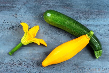 Photo for Close-up on green zucchini and the other yellow with the flower. - Royalty Free Image