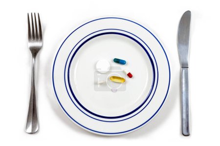 Foto de Medicamentos en un plato sobre fondo blanco. - Imagen libre de derechos
