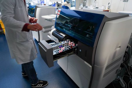 Photo for Technical platform of the Inovie 34 laboratory . A technician handling the Sta R Max 3 Analyzer to analyze blood coagulation and hemostasis. - Royalty Free Image
