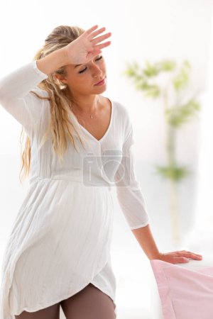 Photo for Young woman leaning on sofa, hand on forehead - Royalty Free Image