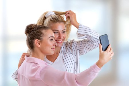 Foto de Dos novias posando para una selfie sobre un fondo claro y borroso. - Imagen libre de derechos