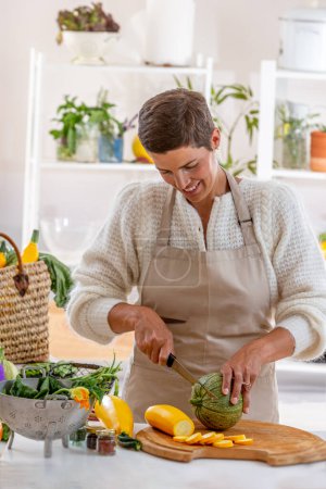 Mujer joven con delantal de cocina rodeado de verduras orgánicas