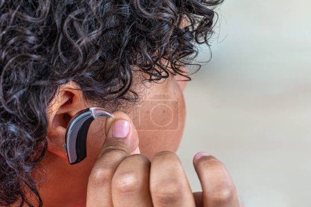 Photo for Young boy installing a hearing aid. - Royalty Free Image