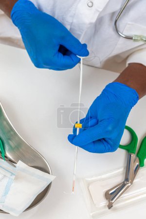 Photo for Doctor holding full copper IUD ready to be placed on a female patient. - Royalty Free Image